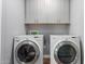 Efficient laundry room with modern washer and dryer units with shelving for organized storage at 10745 W Taft St, Phoenix, AZ 85037