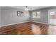 Spacious living room with hardwood floors, a modern chandelier, and a sliding glass door at 10745 W Taft St, Phoenix, AZ 85037