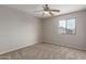 This bedroom offers a window to the outside, tan carpet, neutral walls, and a ceiling fan for comfort at 11132 W Mariposa Dr, Phoenix, AZ 85037
