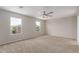 Spacious bedroom with carpet, neutral paint, ceiling fan, and dual windows at 11132 W Mariposa Dr, Phoenix, AZ 85037