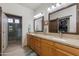 Double vanity bathroom featuring granite counters, framed mirrors, and a glass enclosed shower at 11680 E Sahuaro Dr # 1059, Scottsdale, AZ 85259