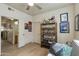 Bedroom with ceiling fan, tiled floor, an organized bookshelf, and open door to bathroom at 11680 E Sahuaro Dr # 1059, Scottsdale, AZ 85259
