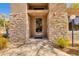 Inviting building entrance with stone accents, a glass door, and well-maintained landscaping at 11680 E Sahuaro Dr # 1059, Scottsdale, AZ 85259