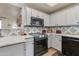 Well-lit kitchen featuring stainless steel appliances, stylish backsplash, and white cabinets at 11680 E Sahuaro Dr # 1059, Scottsdale, AZ 85259