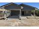 View of the exterior of a single story home with gray siding, a concrete patio, and a carport in progress at 1210 E Garfield St, Phoenix, AZ 85006