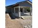 Exterior view of a single-story gray home with a concrete patio and a carport with support beams at 1210 E Garfield St, Phoenix, AZ 85006