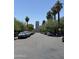 Tree lined street with cars parked on both sides and tall buildings in the distance at 1210 E Garfield St, Phoenix, AZ 85006