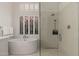 Bright bathroom with a tub and walk-in shower, featuring tiled walls and natural light at 12366 N 129Th St, Scottsdale, AZ 85259