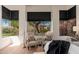 Bright bedroom featuring cushioned chairs, natural light, and black-trimmed windows with views of landscaping at 12366 N 129Th St, Scottsdale, AZ 85259