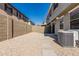 Fully enclosed backyard with rock landscaping, stone pavers, and an AC unit at 1265 S Aaron -- # 271, Mesa, AZ 85209