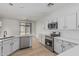 Modern kitchen with stainless steel appliances, sleek white cabinets, and light countertops at 1265 S Aaron -- # 271, Mesa, AZ 85209