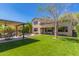 An expansive backyard featuring lush artificial turf, a covered patio, and a private pool with a rock waterfall at 1453 E Elgin Pl, Chandler, AZ 85225