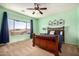 This bedroom features blue walls, a ceiling fan, and a large window providing natural light at 1453 E Elgin Pl, Chandler, AZ 85225
