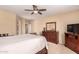 Spacious main bedroom featuring a ceiling fan, ensuite bathroom, and dresser with TV at 1453 E Elgin Pl, Chandler, AZ 85225
