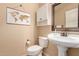 This powder room features a pedestal sink, framed mirror, and charming world map wall art at 1453 E Elgin Pl, Chandler, AZ 85225