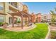 Community space with outdoor picnic tables and lush grass near apartment buildings at 14575 W Mountain View Blvd # 711, Surprise, AZ 85374