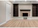 Modern basement featuring a stone fireplace, built-in shelves, and wood-look floors at 1535 E Kenwood St, Mesa, AZ 85203