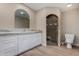 Bathroom featuring an arched tile shower, marble countertop, white cabinets and wood-look floors at 1535 E Kenwood St, Mesa, AZ 85203