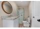 Updated bathroom featuring a modern vanity with a round mirror, glass shower, and white fixtures at 1535 E Kenwood St, Mesa, AZ 85203