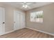 Cozy bedroom with wood-look floors, ceiling fan, and window, adjacent to a closet at 1535 E Kenwood St, Mesa, AZ 85203
