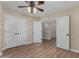 Inviting bedroom with wood-look floors and featuring a ceiling fan and double closets at 1535 E Kenwood St, Mesa, AZ 85203