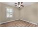 Bedroom featuring wood-look floors, a ceiling fan, and bright natural light from the window at 1535 E Kenwood St, Mesa, AZ 85203