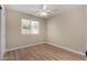 Bright bedroom with wood-look floors, ceiling fan, and a large window offering natural light at 1535 E Kenwood St, Mesa, AZ 85203