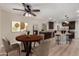 A dining area with a wooden table, upholstered chairs, a ceiling fan, and an open view of the kitchen at 1535 E Kenwood St, Mesa, AZ 85203