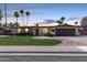 Charming one-story home with fresh landscaping, illuminated windows, and a brick-paved driveway at dusk at 1535 E Kenwood St, Mesa, AZ 85203