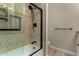 Stylish bathroom shower with mosaic tile accents, black fixtures, and glass door at 1535 E Kenwood St, Mesa, AZ 85203