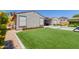 Well-maintained backyard with artificial turf, landscaping, and a cozy patio area at 15753 W Christy Dr, Surprise, AZ 85379