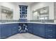 Stylish bathroom with blue cabinetry, double sinks, and a glass-enclosed shower at 15753 W Christy Dr, Surprise, AZ 85379