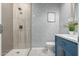 Modern bathroom featuring stylish tiled shower, blue vanity with marble countertop, and patterned wallpaper at 15753 W Christy Dr, Surprise, AZ 85379