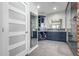 Elegant bathroom featuring blue cabinetry, a large mirror, and glass shower doors at 15753 W Christy Dr, Surprise, AZ 85379