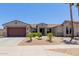 Attractive single-story home with a two-car garage, complemented by well-maintained desert landscaping at 15753 W Christy Dr, Surprise, AZ 85379