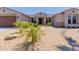 This lovely single-story home has desert landscaping, a two-car garage, and rock features at 15753 W Christy Dr, Surprise, AZ 85379
