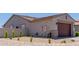View of the exterior shows a two-car garage and desert landscaping on the side of the home at 15753 W Christy Dr, Surprise, AZ 85379