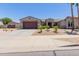 Charming single-story home featuring a two-car garage, desert landscaping, and a welcoming entrance at 15753 W Christy Dr, Surprise, AZ 85379
