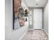 The inviting foyer features tile flooring, artwork, and a stylish rug leading to the front door at 15753 W Christy Dr, Surprise, AZ 85379