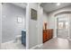 Hallway with gray walls and trim, leading to a bathroom with a blue vanity and a view of a spacious living room at 15753 W Christy Dr, Surprise, AZ 85379