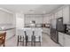 Beautiful kitchen boasts stainless steel appliances, white cabinets, a center island with barstool seating and stylish backsplash at 15753 W Christy Dr, Surprise, AZ 85379