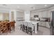 Spacious kitchen features stainless appliances, white cabinetry, large island with bar seating, and a dining area at 15753 W Christy Dr, Surprise, AZ 85379