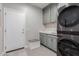 Laundry room equipped with gray washer and dryer, custom cabinets, countertops, and a dog feeding station at 15753 W Christy Dr, Surprise, AZ 85379