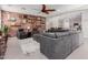Spacious living room features a sectional sofa, brick accent wall, and seamless flow to the kitchen at 15753 W Christy Dr, Surprise, AZ 85379