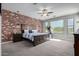Main bedroom featuring a brick accent wall, a ceiling fan, and carpet flooring for ultimate comfort at 15753 W Christy Dr, Surprise, AZ 85379