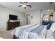 Bright main bedroom boasting a large dresser with television and patterned bedspread at 15753 W Christy Dr, Surprise, AZ 85379