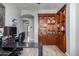 Office space featuring a built-in bookshelf, desk setup, and wood grain tile flooring, leading to the hallway at 15753 W Christy Dr, Surprise, AZ 85379