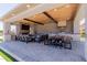 Spacious outdoor space with a built-in grill, comfortable lounge area with fireplace and dining space under a ceiling fan at 15753 W Christy Dr, Surprise, AZ 85379