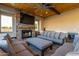 Cozy outdoor space with fireplace and tv, comfortable couches, ceiling fan and beverage fridge at 15753 W Christy Dr, Surprise, AZ 85379