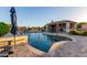 Relaxing backyard with a pool, spa, and outdoor kitchen for entertaining guests at 15753 W Christy Dr, Surprise, AZ 85379